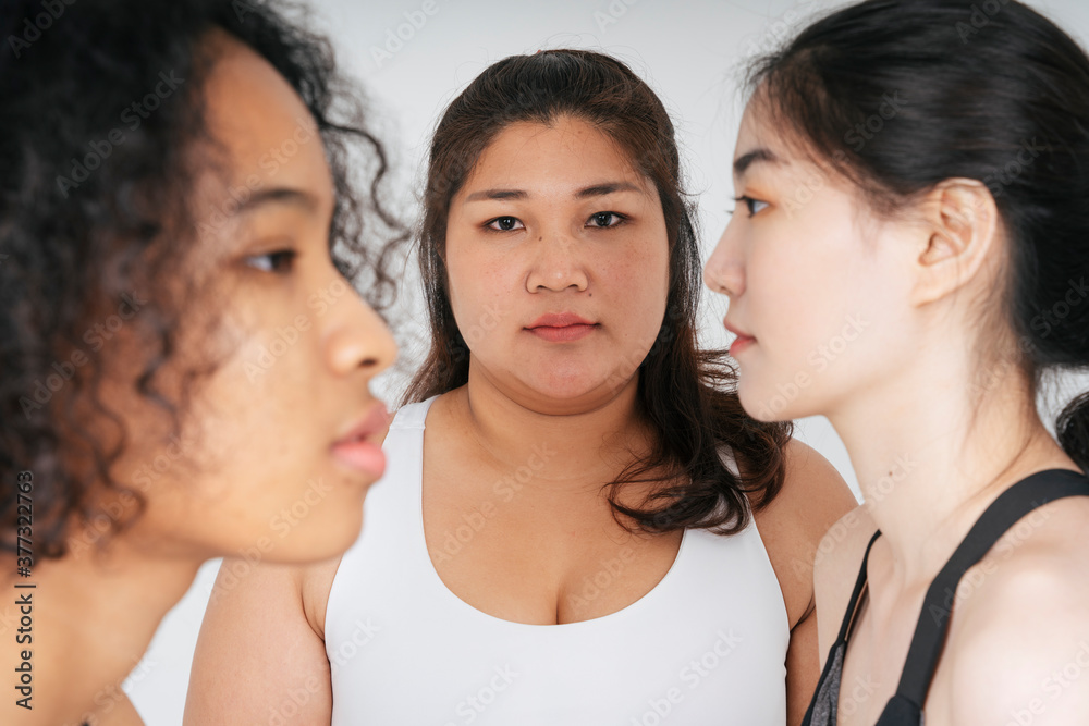 Asian fat women in white sport bra with face of asian and african people on side on white background. Asian fat women in white sport bra with face of asian and african people on side on white background.