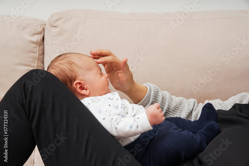 Obraz na płótnie Madre tocando la frente de su bebe w salonie