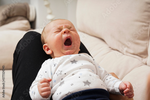Obraz na płótnie Bebe bostezando en las piernas de su madre w salonie