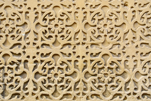 Textured sand stone wall with artistic curve elements. Building with outside rough ornate in Segovia, Spain