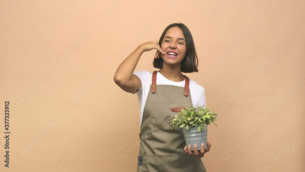 Young gardener indian woman showing a mobile phone call gesture with fingers