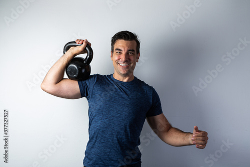 Strong, happy dark man lifting kettlebell