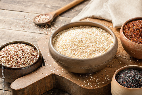 White, red, black and mixed quinoa on wooden table