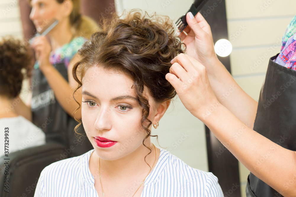 Fototapeta premium young woman gets her hair done in a beauty salon