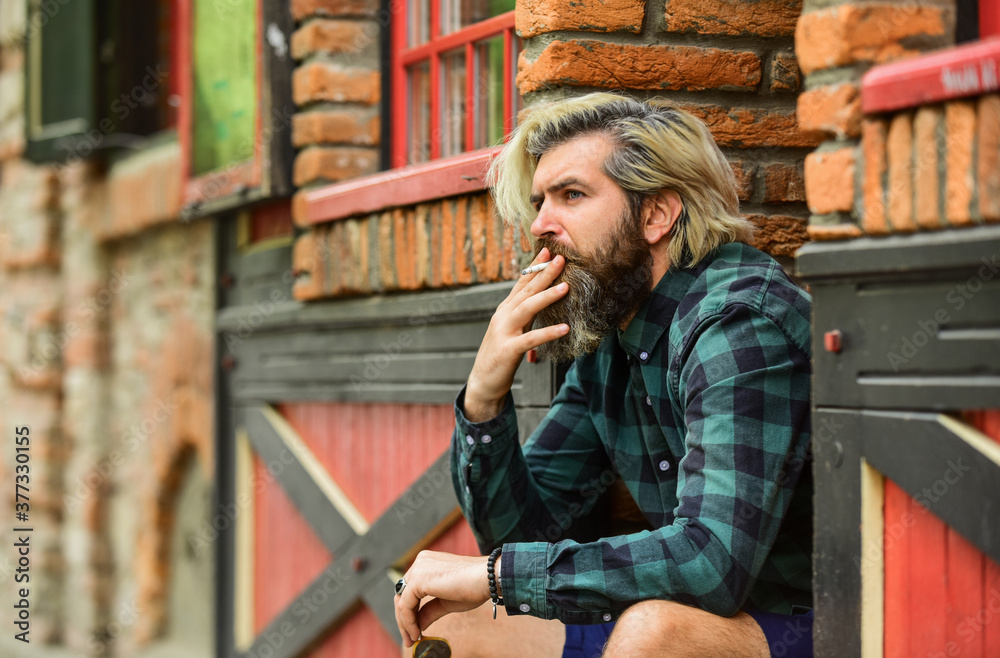 Smoking habit. Guy in sunglasses smoking tobacco. Smoking outdoors. Man with cigarette. Cool guy relaxing. Reduce stress. Mental health. Hipster smoking old architecture background. Medical cannabis Smoking habit. Guy in sunglasses smoking tobacco. Smoking outdoors. Man with cigarette. Cool guy relaxing. Reduce stress. Mental health. Hipster smoking old architecture background. Medical cannabis