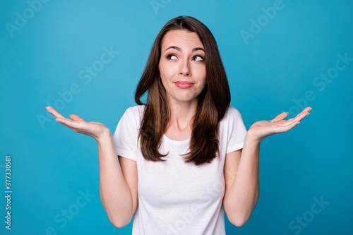 Sorry I don't care. Photo of attractive funny lady hold arms hands up shrug shoulders not feel guilty bad person wear casual white t-shirt isolated blue color background