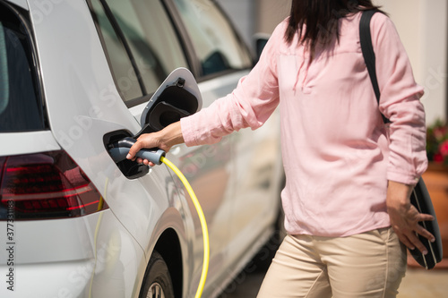 Woman charging electric car 