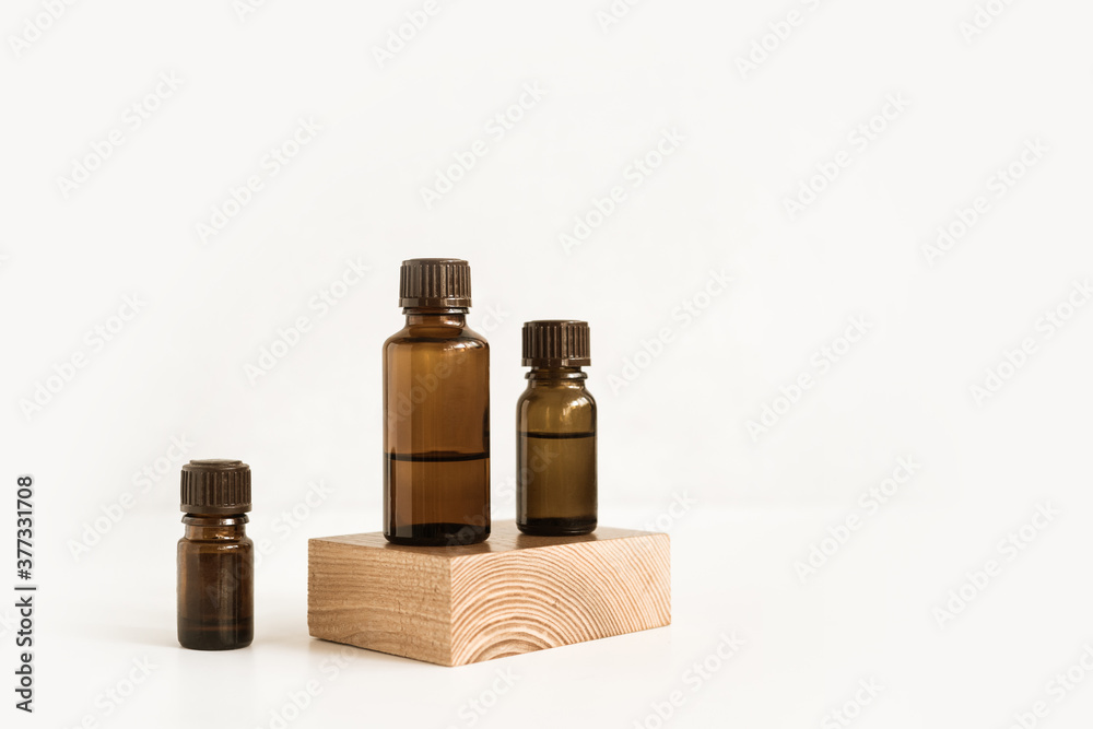 Bottles essential oils on wooden stand on white background. Hemp oil. CBD cannabis products. Minimalistic fragrant concept. Natural medicine