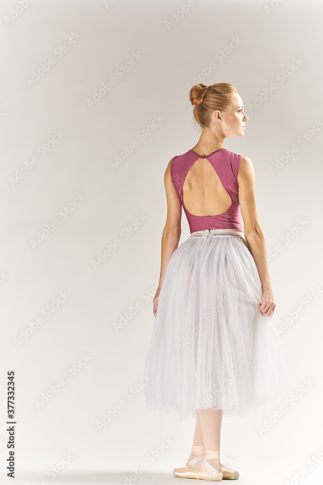 woman ballerina in pointe shoes and in a tutu on a light background poses posing legs dance model woman ballerina in pointe shoes and in a tutu on a light background poses posing legs dance model