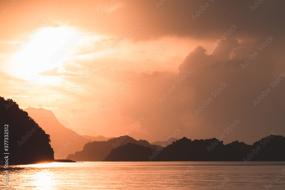 Sunset mountains silhouette over ocean