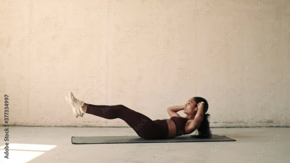 Young african fitness woman making sport abs exercises isolated over white wall background Young african fitness woman making sport abs exercises isolated over white wall background