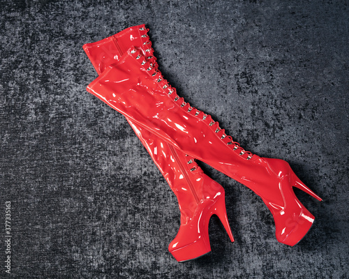 Kinky red high lacquer boots on a dark chic background
