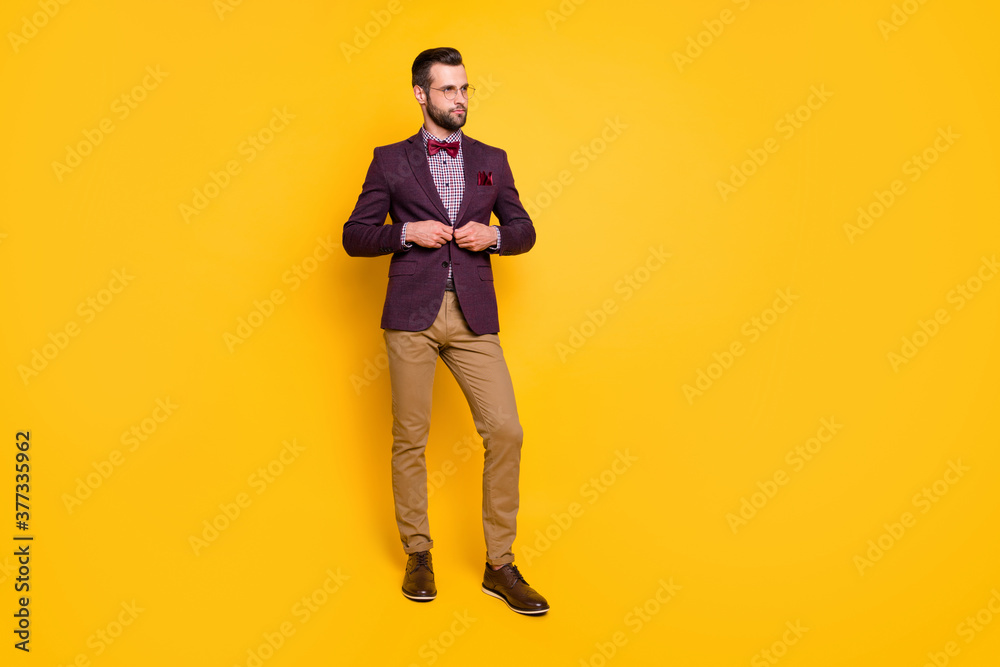 Full length body size view of his he nice attractive content fashionable guy boyfriend fastening button dressing isolated over bright vivid shine vibrant yellow color background Full length body size view of his he nice attractive content fashionable guy boyfriend fastening button dressing isolated over bright vivid shine vibrant yellow color background
