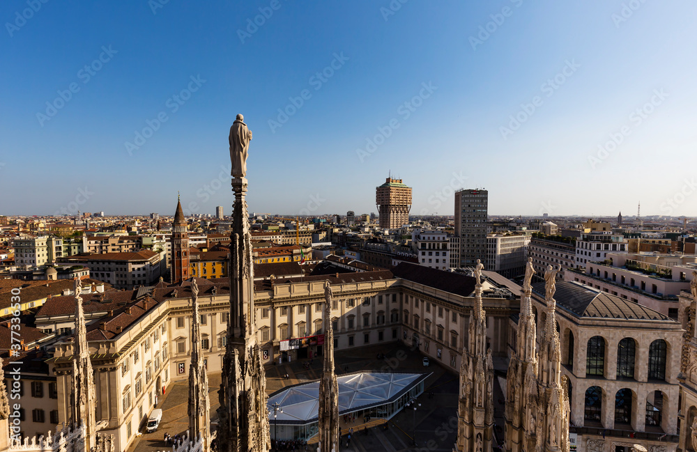 Aerial view of Milan Italy from Cathedral Duomo rooftop terrace with statue