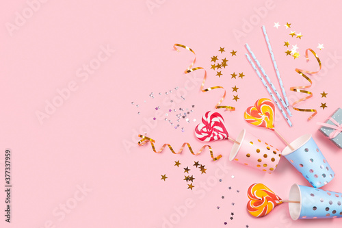Birthday party supplies on pink background. Top view. Copy space.