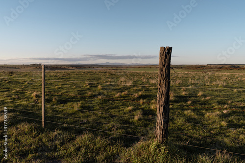 Rural fence made with wires in middle of countryside.