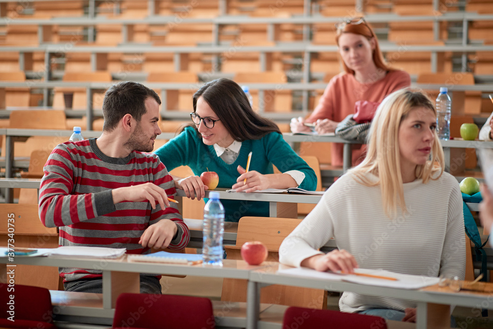 Students chatting at a lecture Students chatting at a lecture