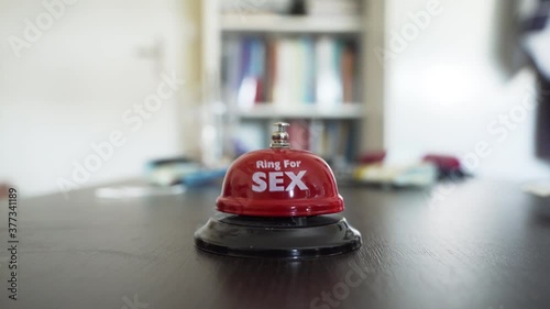 Young Woman Pushes patiently a Bell named 