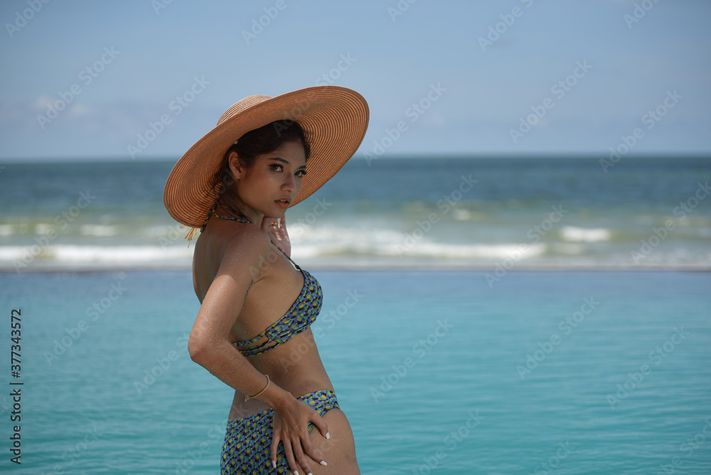 Sexy woman in bikini swimwear with slim body in swimming pool near the beach/concept summer holiday vacation