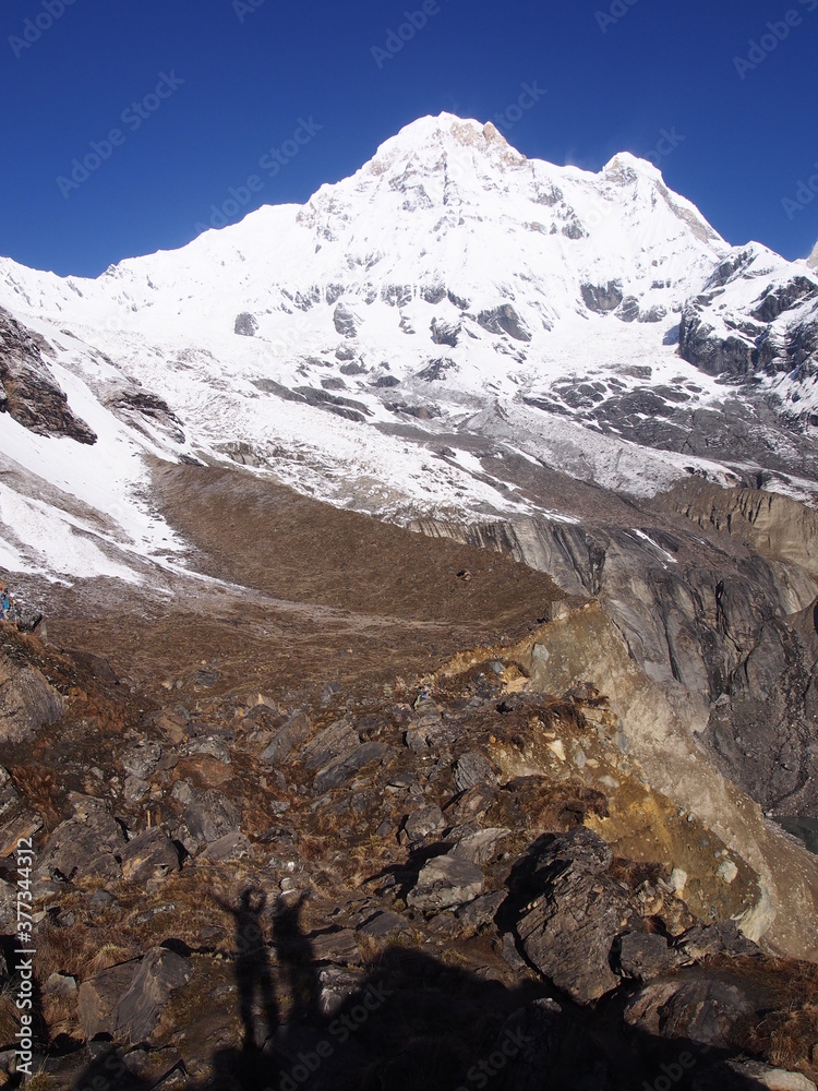 The snow-covered Himalayas and the shadow of the climbers, ABC (Annapurna Base Camp) Trek, Annapurna, Nepal