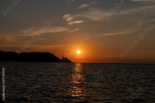 Sonnenuntergang mit Stadt und Bergen im Meer