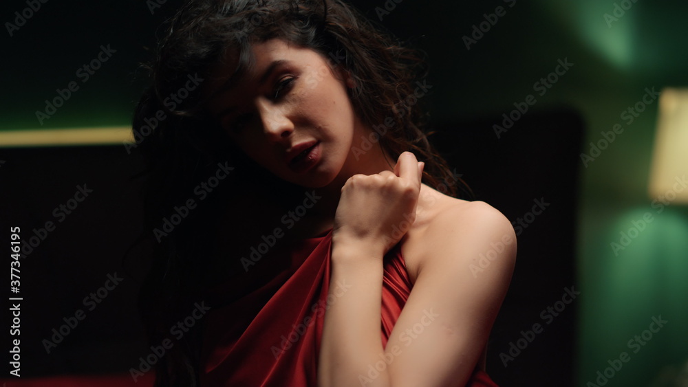 Nude woman biting lip indoors. Sensual girl playing with red silk sheet. Nude woman biting lip indoors. Sensual girl playing with red silk sheet.