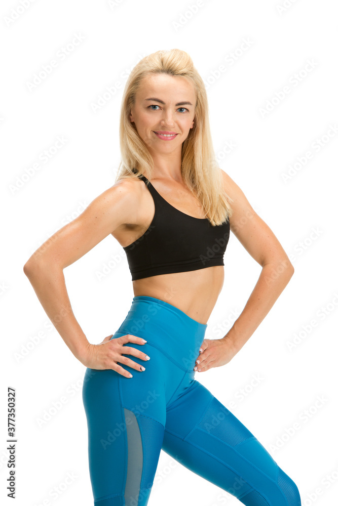 Smiling. Beautiful female fitness coach practicing isolated on white studio background, showing exercises. Caucasian blonde model in sport outfit. Professional occupation, active and healthy lifestyle Smiling. Beautiful female fitness coach practicing isolated on white studio background, showing exercises. Caucasian blonde model in sport outfit. Professional occupation, active and healthy lifestyle