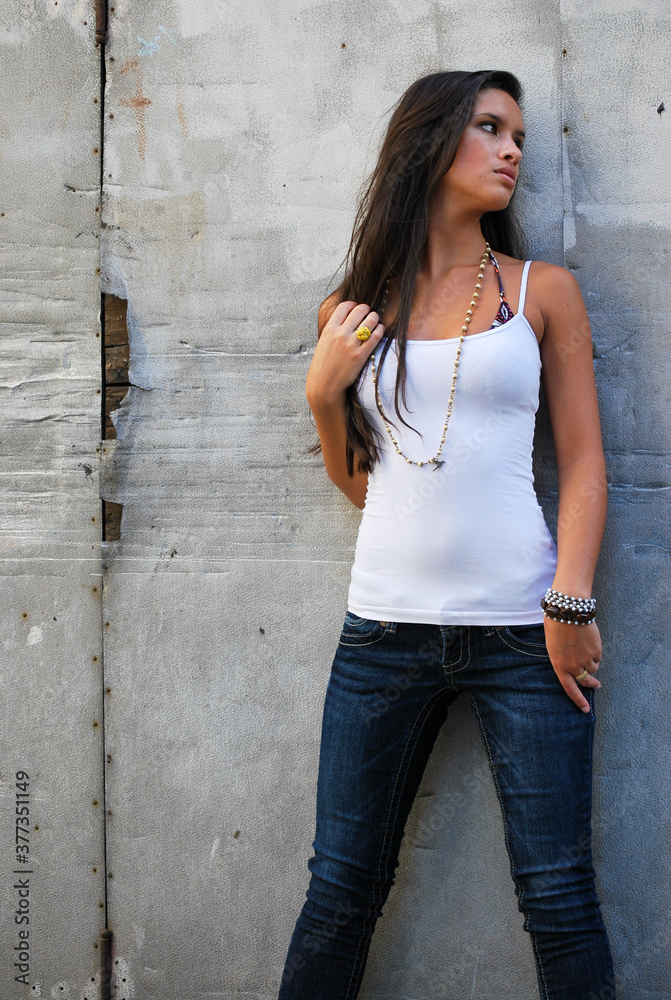 Sexy beautiful female brunette long hair jeans urban concrete Sexy beautiful female brunette long hair jeans urban concrete