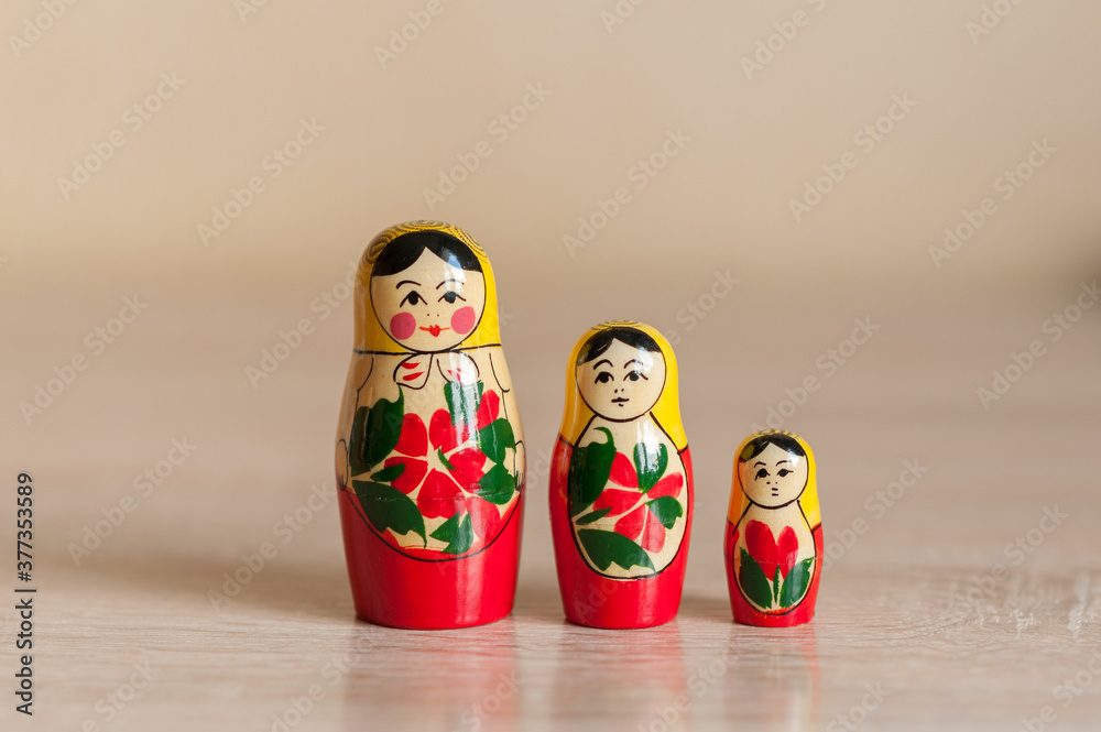 matryoshka.Russian doll. matryoshka. three dolls stand on a beige background. matryoshka.Russian doll. matryoshka. three dolls stand on a beige background.