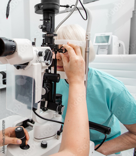 Senior woman examined by an ophthalmologist on ophthalmic equipment, eye exam, eye test photo