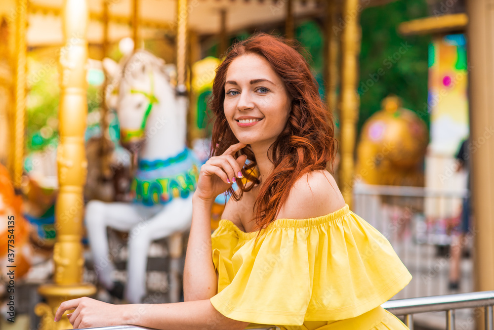 Obraz premium Happy beautiful redhead girl walking in the park