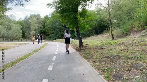 Wallpaper Mural Hipster woman riding on Electric Scooter on the special bicycle line in the park environment Torontodigital.ca