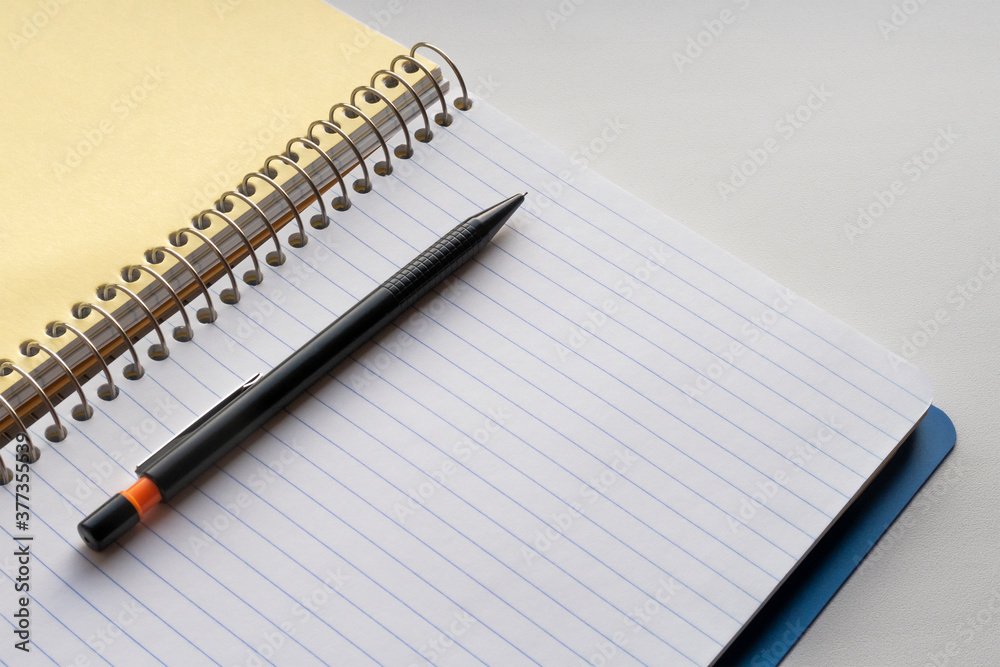 Open spiral notebook and black pencil. Copy space for text Open spiral notebook and black pencil. Copy space for text