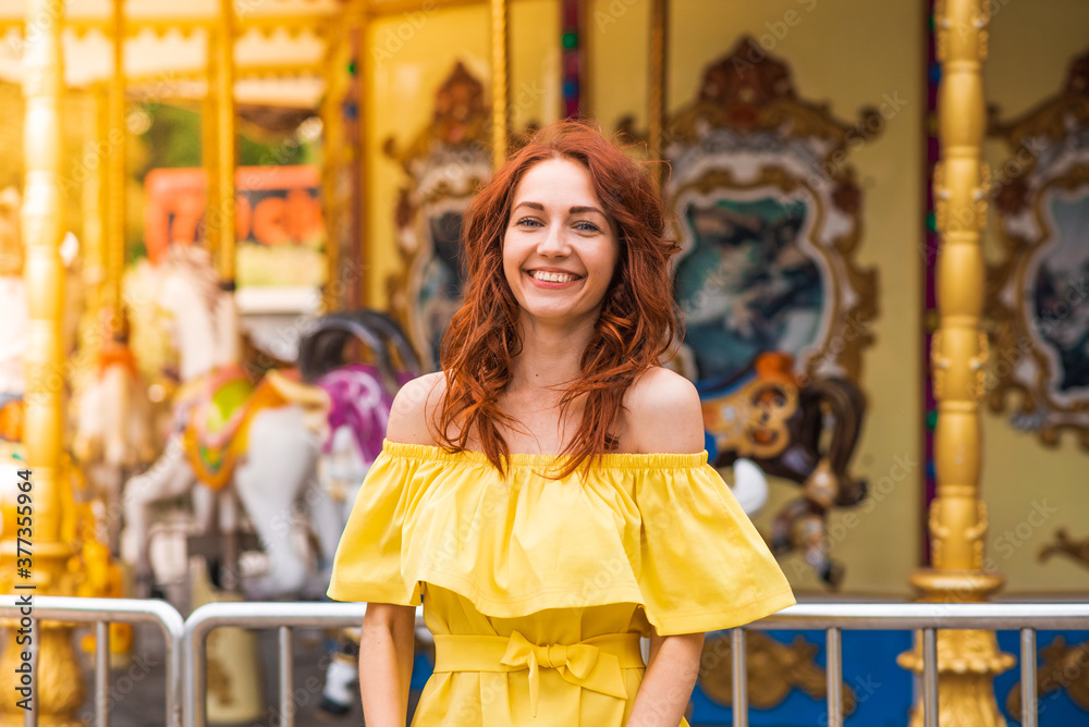 Happy beautiful redhead girl walking in the park