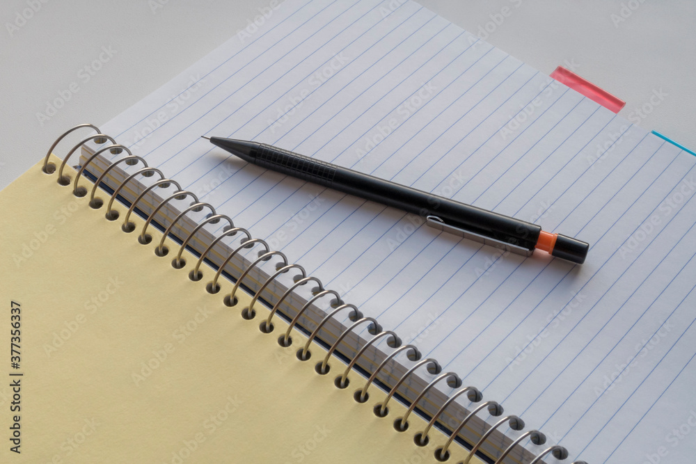 Open spiral notebook with subject separators and black pencil. Blank page. Copy space for text. Open spiral notebook with subject separators and black pencil. Blank page. Copy space for text.