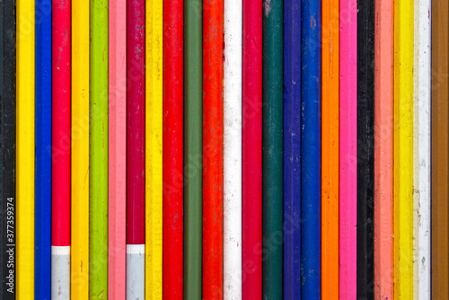 colored pencils in a row, on a black table