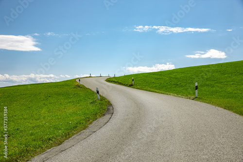 Landstrasse in grüner hügeliger Landschaft
