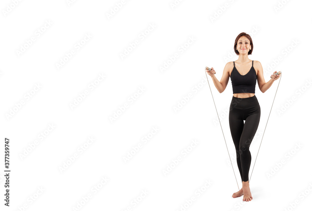young beautiful woman in black leggings and top doing fitness and yoga indoors, on a white background, isolate