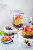 White wine sangria or punch with berries and ice in glass and pincher. Homemade refreshing fruit sangria.