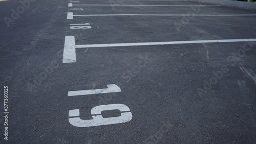 Close-up of a white paint number marking in a parking lot. Empty parking lot, Parking lot with white mark, Open parking in public park. Number 19.