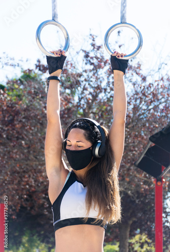 Athletic young woman doing exercise in a callisthenics park