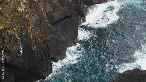 Close up of the ocean breaking against the giant rocks in the coast of spain