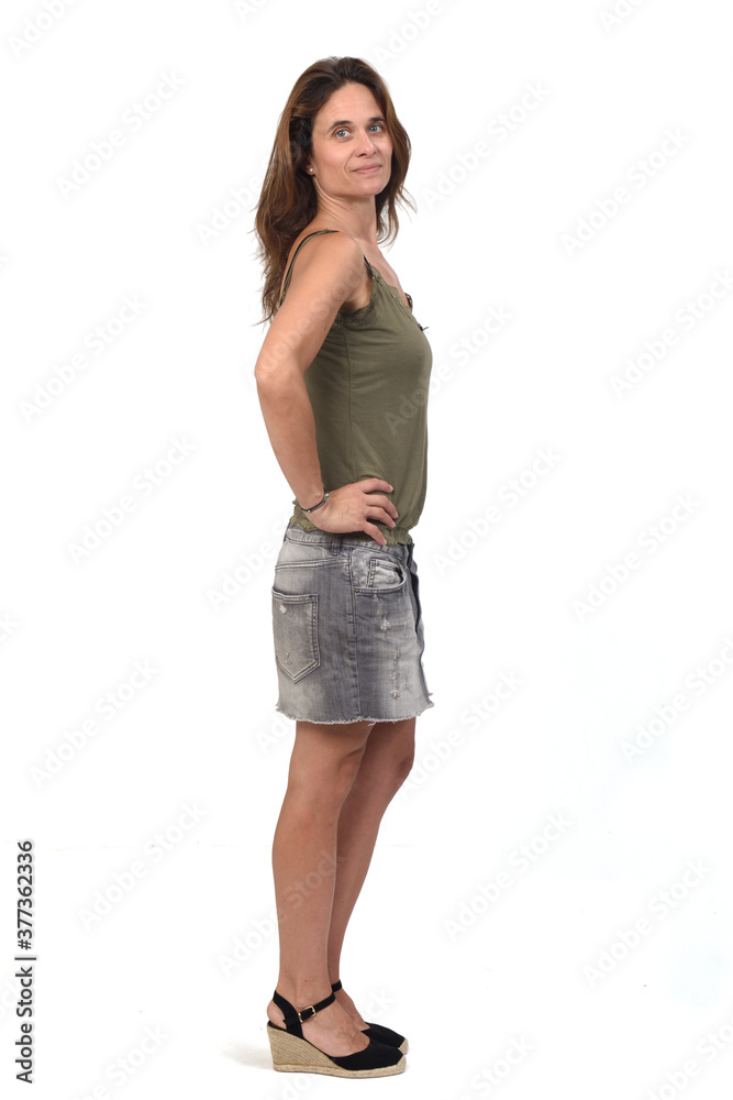 full portrait of a woman in a denim skirt on white background, hand on hip and looking at camera full portrait of a woman in a denim skirt on white background, hand on hip and looking at camera