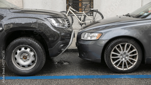2 anonymous cars parked very close and facing each other