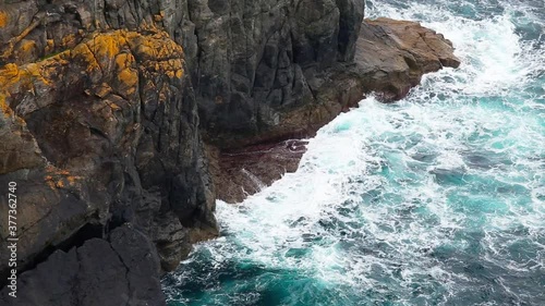 Close up of the ocean breaking against the giant rocks in the coast of spain