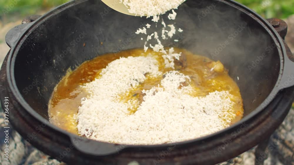 The preparation of traditional Uzbek pilaf with meat, carrots, garlic and spices. Beautiful and tasty in a large pan. The preparation of traditional Uzbek pilaf with meat, carrots, garlic and spices. Beautiful and tasty in a large pan.
