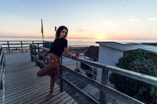 Chica guapa posando en balcon de madera al atardecer en Cadiz