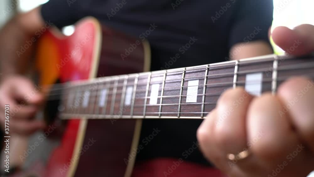 MANI DI UOMO ADULTO SUONANO LA CHITARRA ACUSTICA ARPEGGIANDO ESEGUENDO NOTE MUSICALI