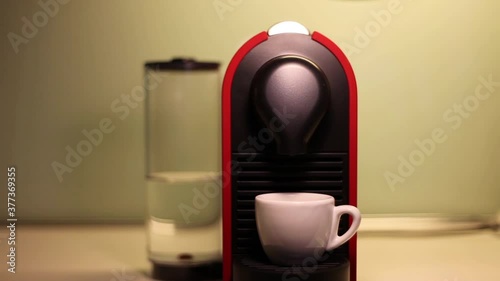 Espresso coffee machine with capsules pouring coffee in a cup