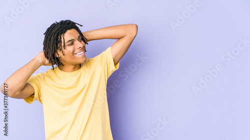 Young african american rasta man feeling confident, with hands behind the head.